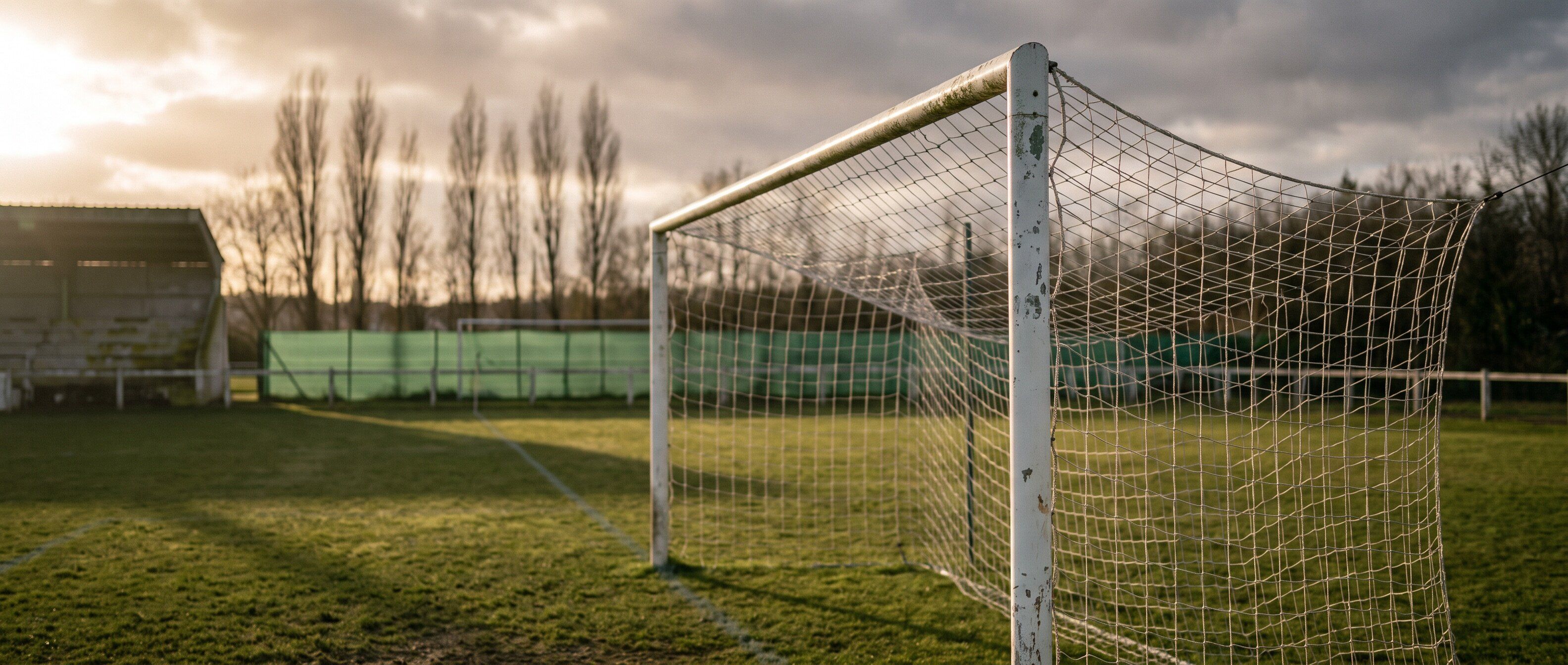Une cage de foot amateur vue depuis le point de penalty, en fin d'après-midi